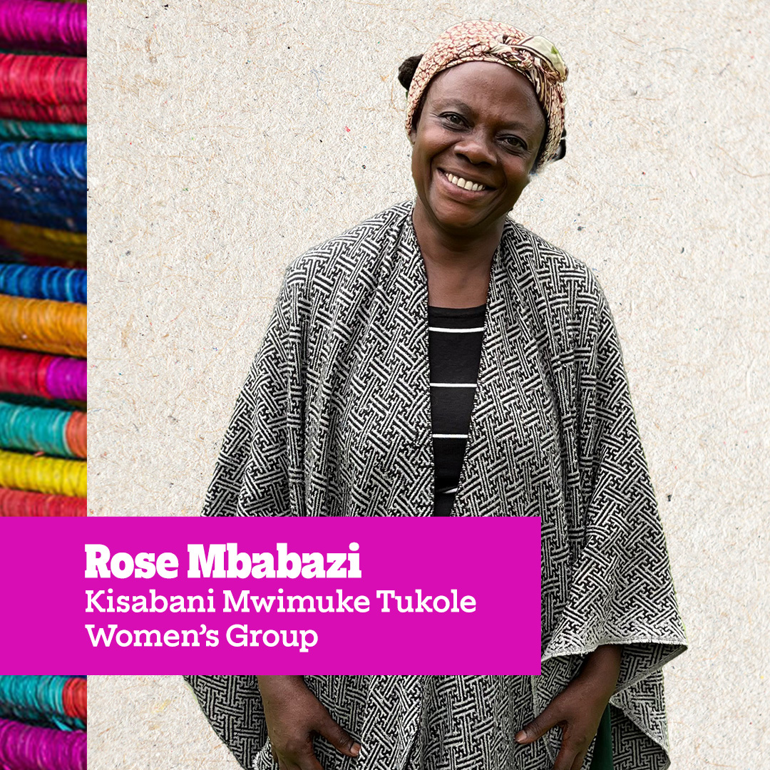 A woman named Rose Mbabazi from the Kisabani Mwimuke Tukole Women’s Group, smiling and standing against a neutral background.